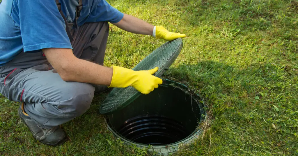 Opening Septic tank lid to inspect for flooded tank